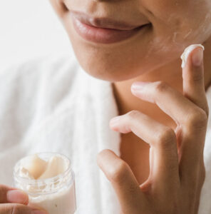 woman applying cream to her face