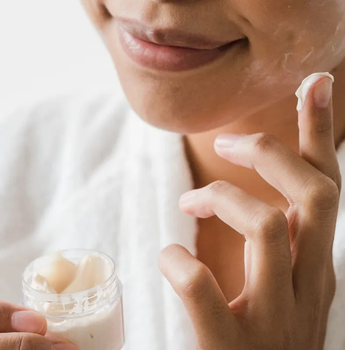 woman applying cream to her face