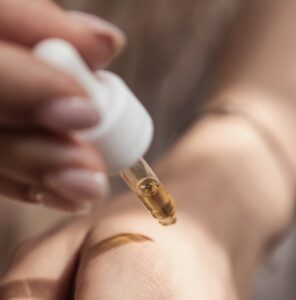 A person applying face serum on their wrist