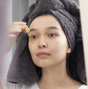 A woman applying face serum