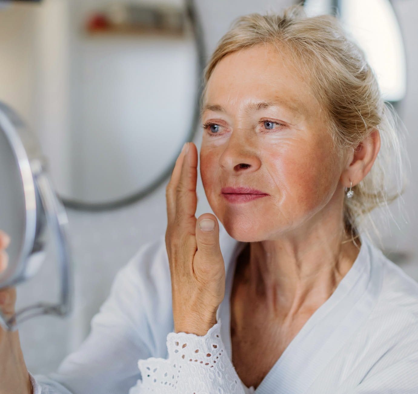 Mature woman checking her skin in a mirror